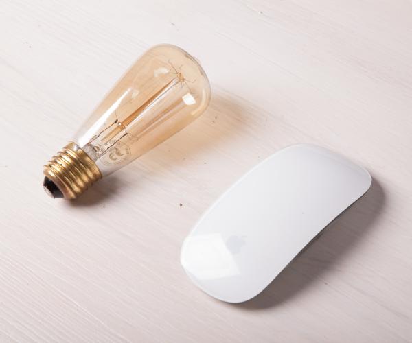 a lightbulb and a white computer mouse are next to each other