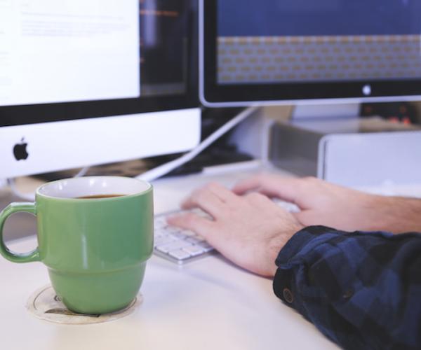 cup of coffee by a computer