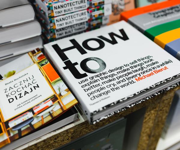 a stack of books and the main focus is a book that says "how to" in large text