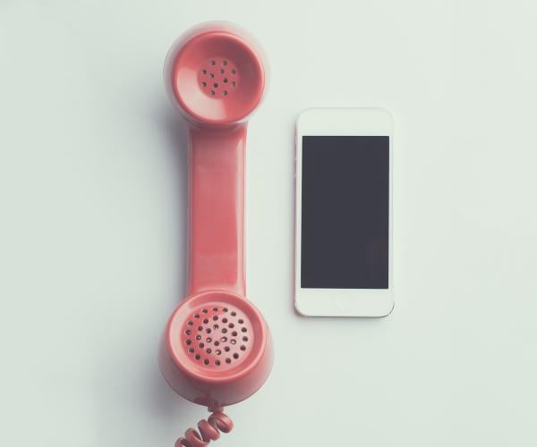 an old cord phone and an iphone next to each other