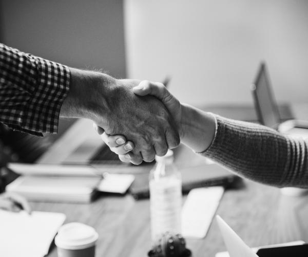 two people shaking hands. the photo is black and white
