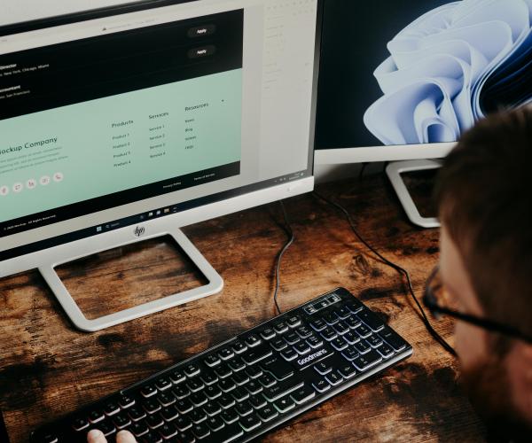 Man sitting at desk reviewing a website.