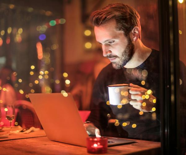 Man staring at his laptop working into the night.