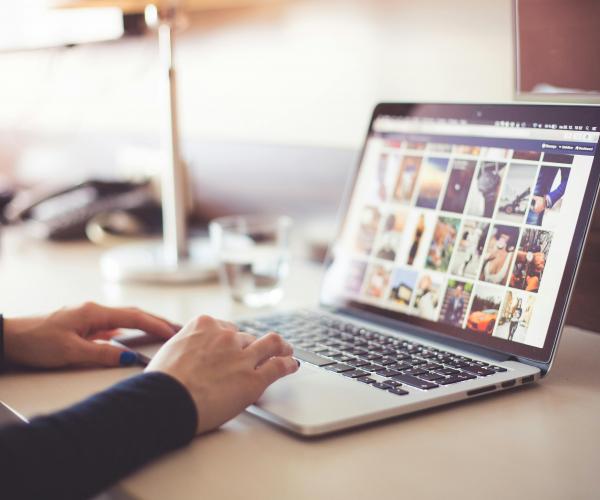 Person sitting at a laptop and browsing an image gallery.