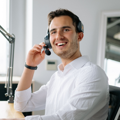 Man smiling while on a phone call using his headset.