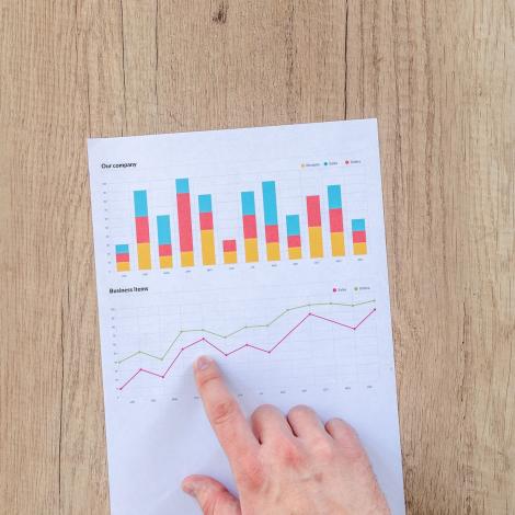 hand pointing at paper with statistics
