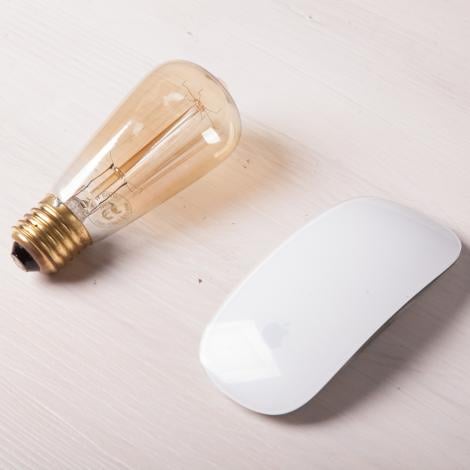 a lightbulb and a white computer mouse are next to each other
