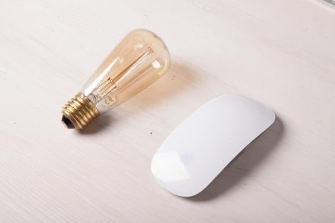 a lightbulb and a white computer mouse are next to each other