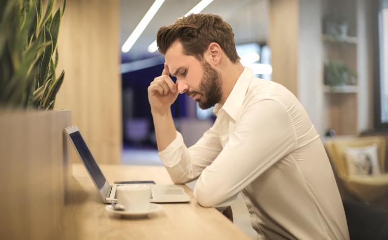 man looking at laptop looking upset