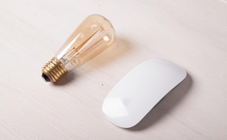 a lightbulb and a white computer mouse are next to each other