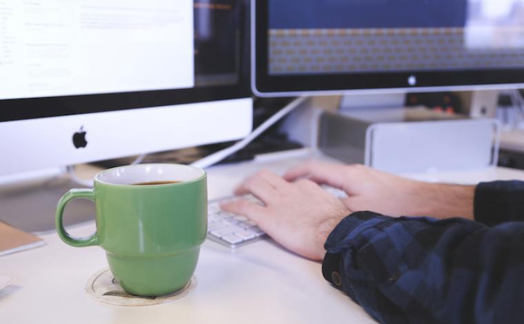 cup of coffee by a computer