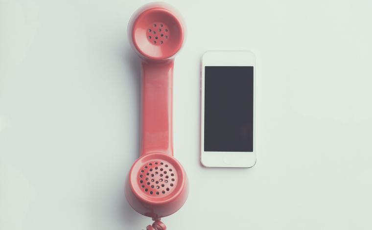 an old cord phone and an iphone next to each other