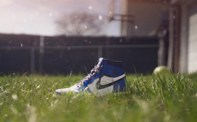 a blue nike shoe in a grass field