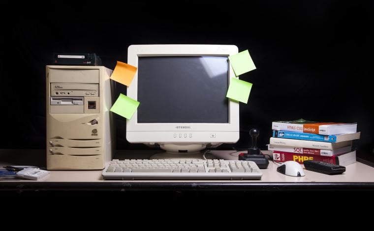 an old computer turned off with sticky notes of various colors attached to the screen
