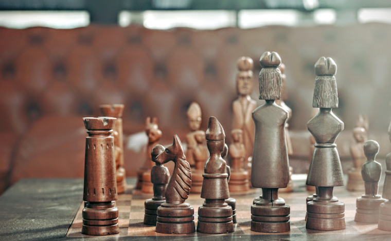 a chess board with wooden chess pieces on top of a table